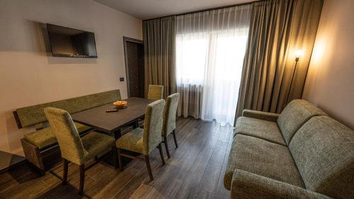 a living room with a table and a couch at Hotel Martellerhof in Martello