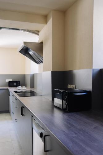 a kitchen with a black counter top in a room at Boutique-Capsule Hostel in Warsaw
