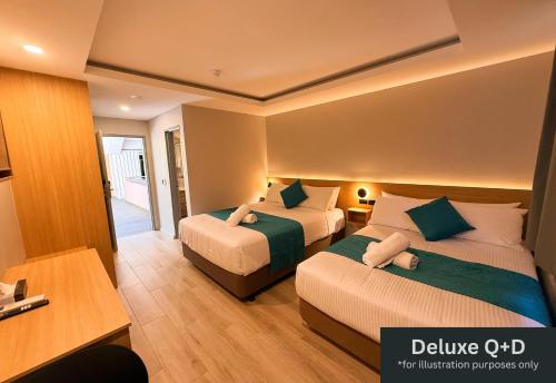 a hotel room with two beds and a desk at Marco Polo Motor Inn Sydney Hotel in Sydney