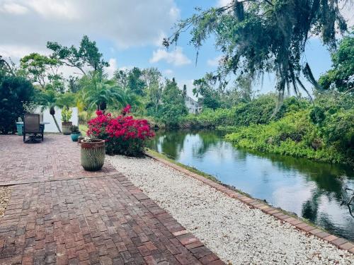 a brick walkway next to a river with flowers at Sarasota Charm in Sarasota
