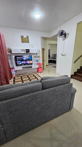 a living room with a couch and a tv at Homestay ZaraMelly Kuala Terengganu in Kuala Terengganu
