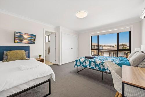 a bedroom with a bed and a large window at KozyGuru | Austral | Charming 4Bedroom Family Home in Austral
