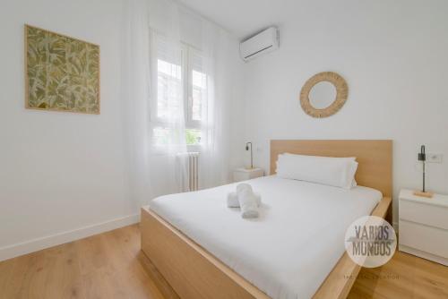 une chambre blanche avec un lit blanc et une fenêtre dans l'établissement Estilo con parking para 4, vive La Latina, à Madrid