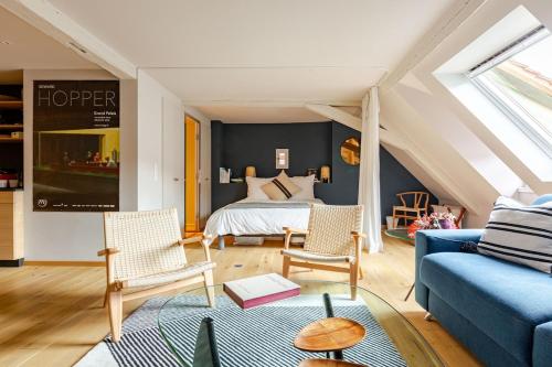 - une chambre mansardée avec un lit et un canapé bleu dans l'établissement STRAS'LOFT - Hypercentre - Haut de Gamme - Cathédrale - Confort - Calme, à Strasbourg