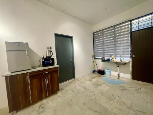 a kitchen with a refrigerator and a sink in a room at CozySukun40#6pax#Netflix#NearIconCity#BukitMertajam in Bukit Mertajam