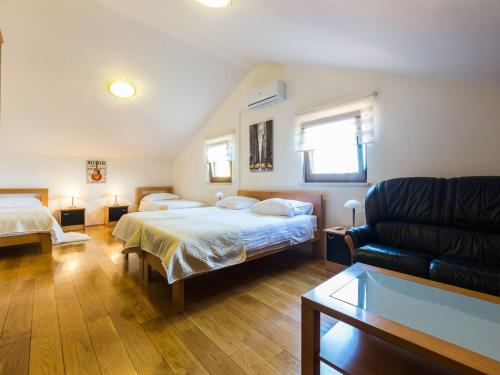 una habitación de hotel con dos camas y un sofá en Modern Escape with Private Pool Sauna Game Room BBQ near Zadar, en Zadar