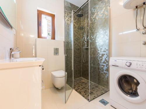 Un baño con inodoro y cabina de ducha de cristal. en Modern Escape with Private Pool Sauna Game Room BBQ near Zadar, en Zadar