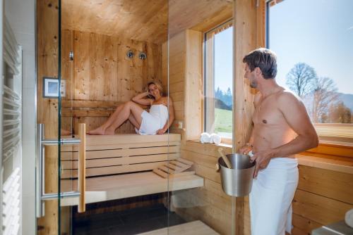 a man and a woman in a sauna at Rittis Alpin Chalets Dachstein in Ramsau am Dachstein