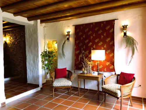 a porch with two chairs and a table with a lamp at Casal da Serrana in Óbidos