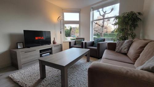 a living room with a couch and a tv at Villa Amsteldijck (8km from Amsterdam) in Ouderkerk aan de Amstel