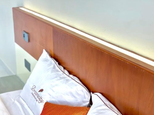 a wooden headboard with a white pillow on a bed at SKY VILLA - BKK Phnom Penh - Rooms & Apartments - FREE LAUNDRY in Phnom Penh