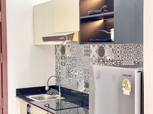 a kitchen with a sink and a refrigerator at SKY VILLA - BKK Phnom Penh - Rooms & Apartments - FREE LAUNDRY in Phnom Penh