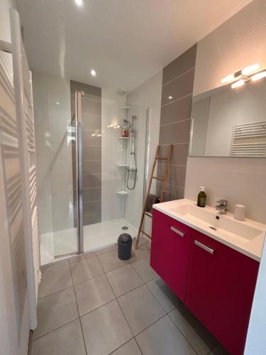 La salle de bains est pourvue d'un lavabo rouge et d'une douche. dans l'établissement Maison de Famille La Bernerie, à La Bernerie-en-Retz