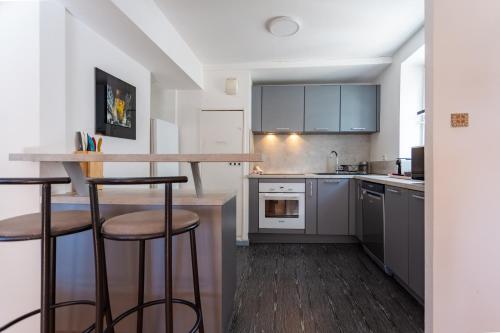 une cuisine avec un comptoir et deux tabourets de bar dans l'établissement Evasion Cathédrale, à Strasbourg