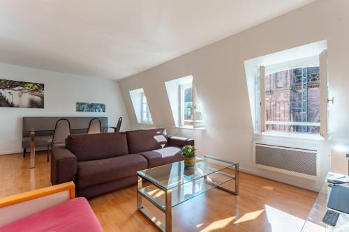 un salon avec un canapé et une table en verre dans l'établissement Evasion Cathédrale, à Strasbourg