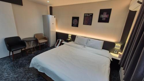 a hotel room with a bed and a table and chairs at Hotel Demeure in Daejeon