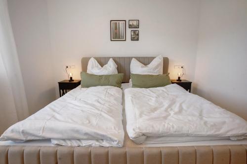 a bedroom with two beds with white sheets and pillows at wanderlutz in Baiersbronn