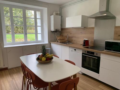 une cuisine avec une table avec un bol de fruits dessus dans l'établissement Gite des Oiseaux 3 CHAMBRES, à Saint-Antoine-de-Ficalba
