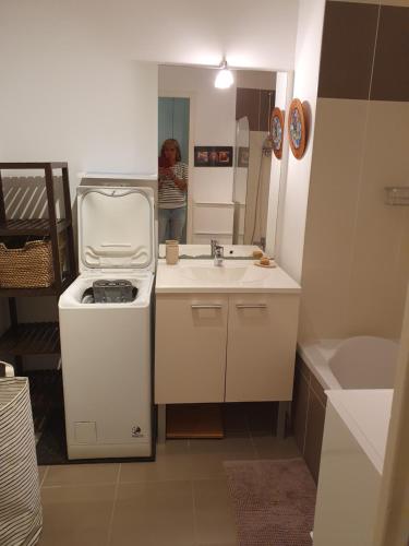 une femme debout dans une petite cuisine avec un évier dans l'établissement Superbe appartement 4 personnes, à Pornichet