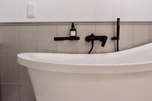 a white sink in a white tiled bathroom at Nid cosy au vert idéal pour escapade romantique in Tohogne