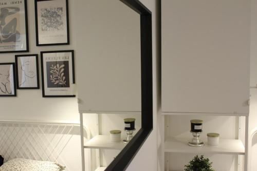 a hallway with a mirror and framed pictures on the wall at Nid cosy au vert idéal pour escapade romantique in Tohogne
