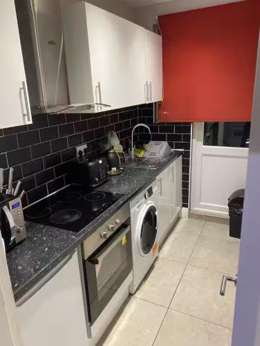 a kitchen with a stove and a washing machine at Breeze on Southend in Essex in Southend-on-Sea