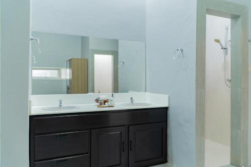 a bathroom with two sinks and a large mirror at The Hawk's Nest Resort in Sabong