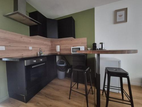 une cuisine avec un comptoir, une table et des tabourets dans l'établissement Milano, 4 Pers, Centre-ville, Confortable, à Reims