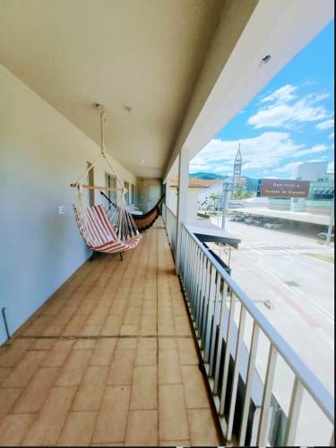 a balcony with two chairs and a view of an airport at Apartamento Família Termas in Gravatal