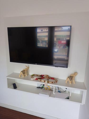 a flat screen tv hanging on a white wall at Apartamento Família Termas in Gravatal