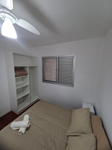 a small bedroom with a bed and a window at Apartamento Família Termas in Gravatal
