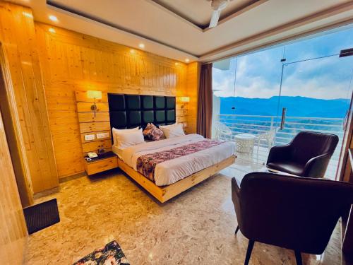 a bedroom with a bed and a large window at The Classic Hill View Hotel, Near JW Marriott Mussoorie in Mussoorie