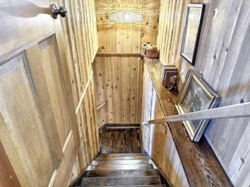 a wooden hallway with a staircase in a train car at The Spotted Owl in Highlands