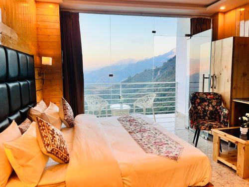 a bedroom with a bed and a balcony with a view at The Classic Hill View Hotel, Near JW Marriott Mussoorie in Mussoorie