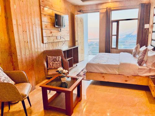 a bedroom with a bed and a couch and a table at The Classic Hill View Hotel, Near JW Marriott Mussoorie in Mussoorie