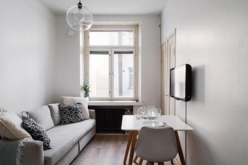 un salon avec un canapé et une table dans l'établissement Cozy Renovated Studio in Kallio near Metro Station, à Helsinki