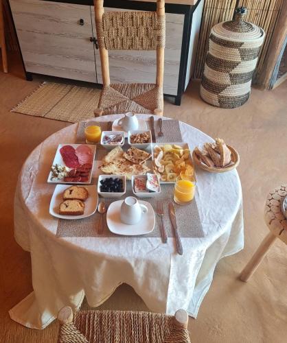 een tafel met ontbijtproducten op een witte tafeldoek bij Kalimba Luxury Desert Camp in Merzouga