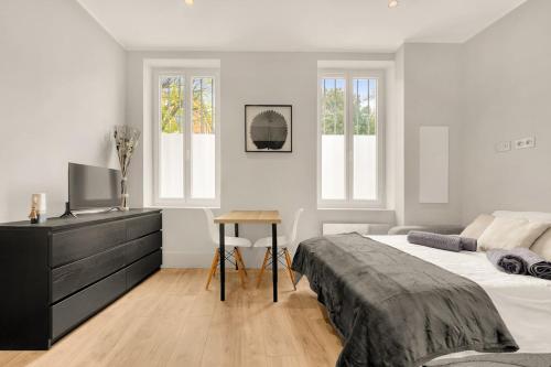 une chambre avec un lit et un bureau avec une télévision dans l'établissement Studio Tolosan - Cosy Tram & Bord de Garonne, à Toulouse
