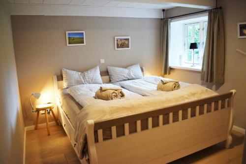 a bedroom with a bed with two dogs laying on it at Reetdachhaus Frieda Aventoft in Aventoft