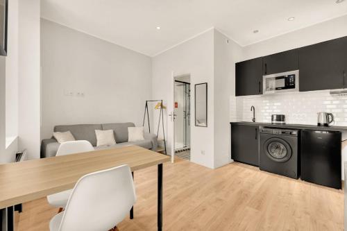 Il comprend une cuisine et un salon avec une table et un lave-linge. dans l'établissement Studio Tolosan - Cosy Tram & Bord de Garonne, à Toulouse