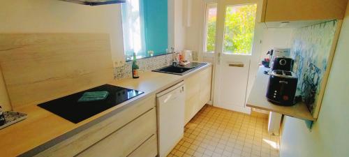 une petite cuisine avec un évier et un réfrigérateur dans l'établissement Grande maison proche Dieppe, idéal familles et professionnels, à Dieppe