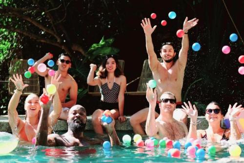 a group of people sitting in a swimming pool with balls at Mad Monkey Dumaguete in Dumaguete