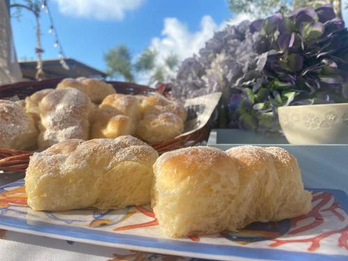 een bord gebak op een tafel met een mand brood bij Il Casale di Punta Prosciutto in Punta Prosciutto