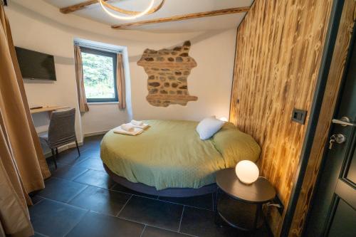 Un dormitorio con una cama y una mesa y una ventana. en La Torre, en Licciana Nardi