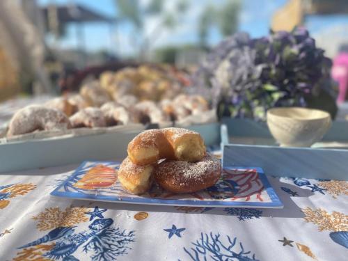 een tafel met twee schalen donuts erop bij Il Casale di Punta Prosciutto in Punta Prosciutto