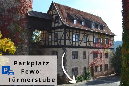 a building with a sign in front of it at TÜRMERSTUBE - Scandi Style - in der historischen Hinterburg Schlitz - nahe Fulda in Schlitz