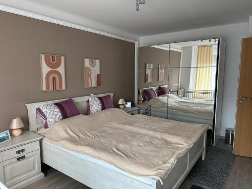 a bedroom with a large bed and a mirror at Ferienhaus Morgenstern in Wilhelmshaven