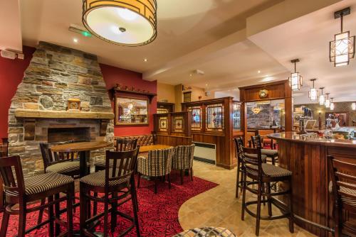 a restaurant with a bar and a fireplace at Corr's Corner Hotel in Newtownabbey