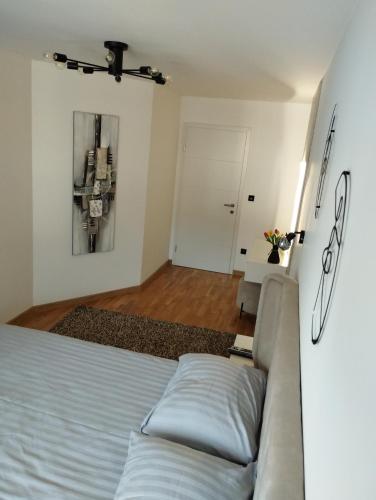 a living room with a bed and a couch at EM apartman Tuzla in Tuzla