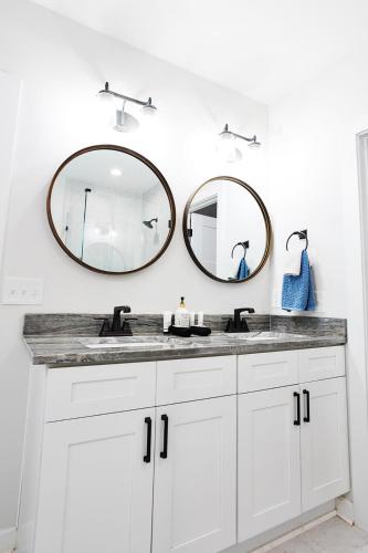 a bathroom with two mirrors above a white sink at Elmwood Park Retreat Renovated 3 Bed 2 Bath DT in Columbia